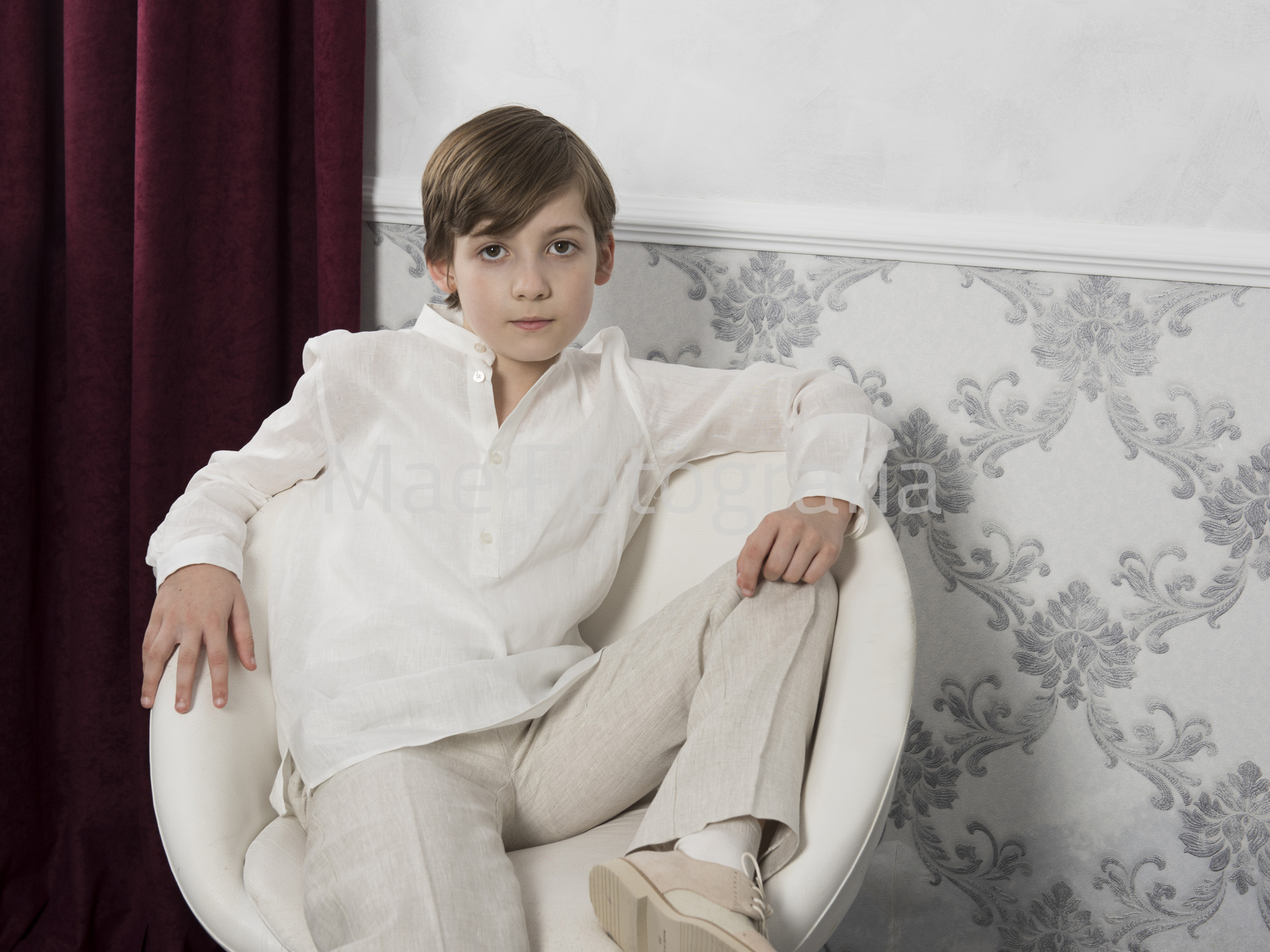 Niño en silla blanca. Reportaje de comunión